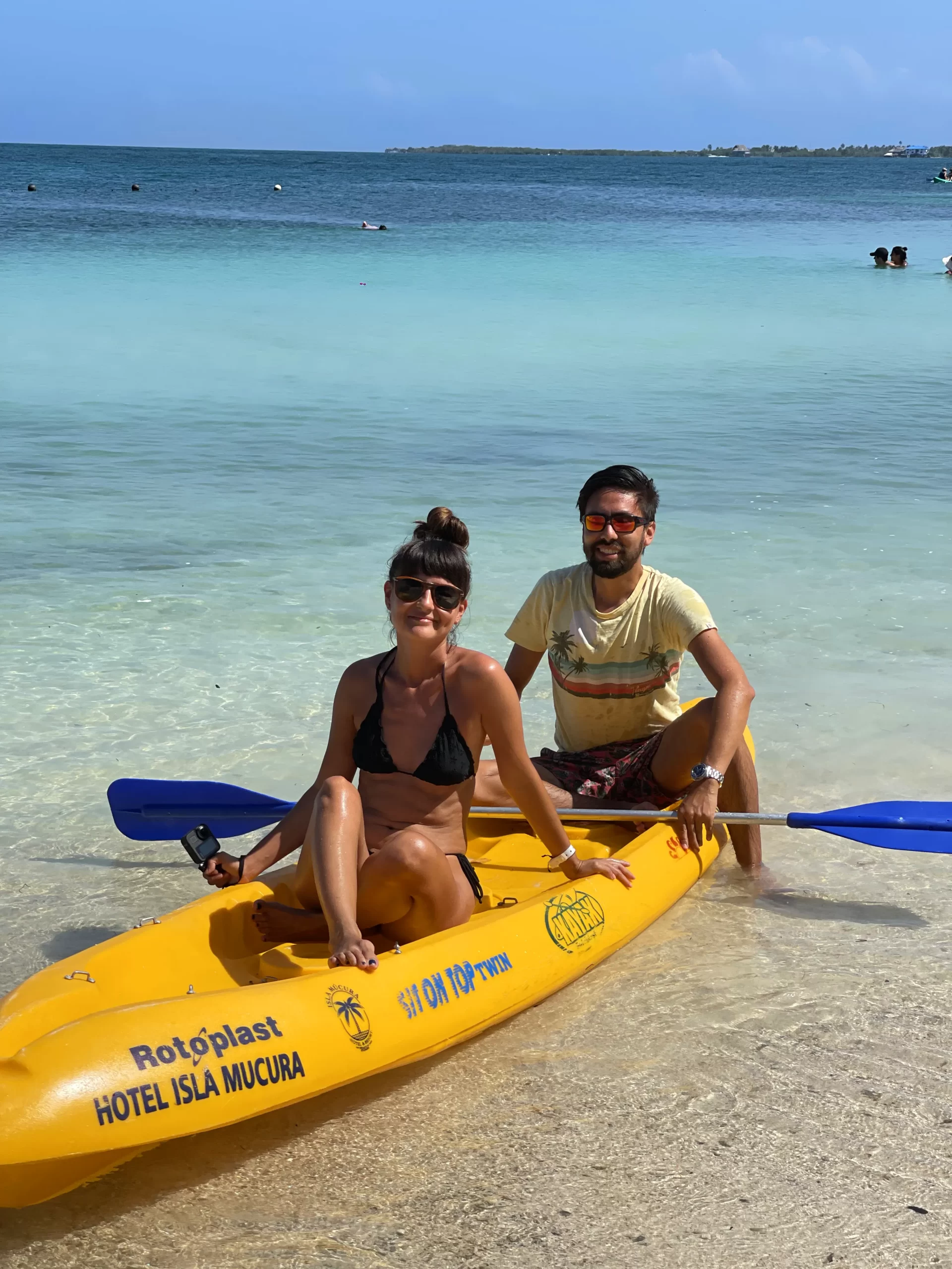 Una pareja sonriente rema tranquilamente en kayak, explorando las aguas cristalinas que rodean la hermosa Isla Múcura.