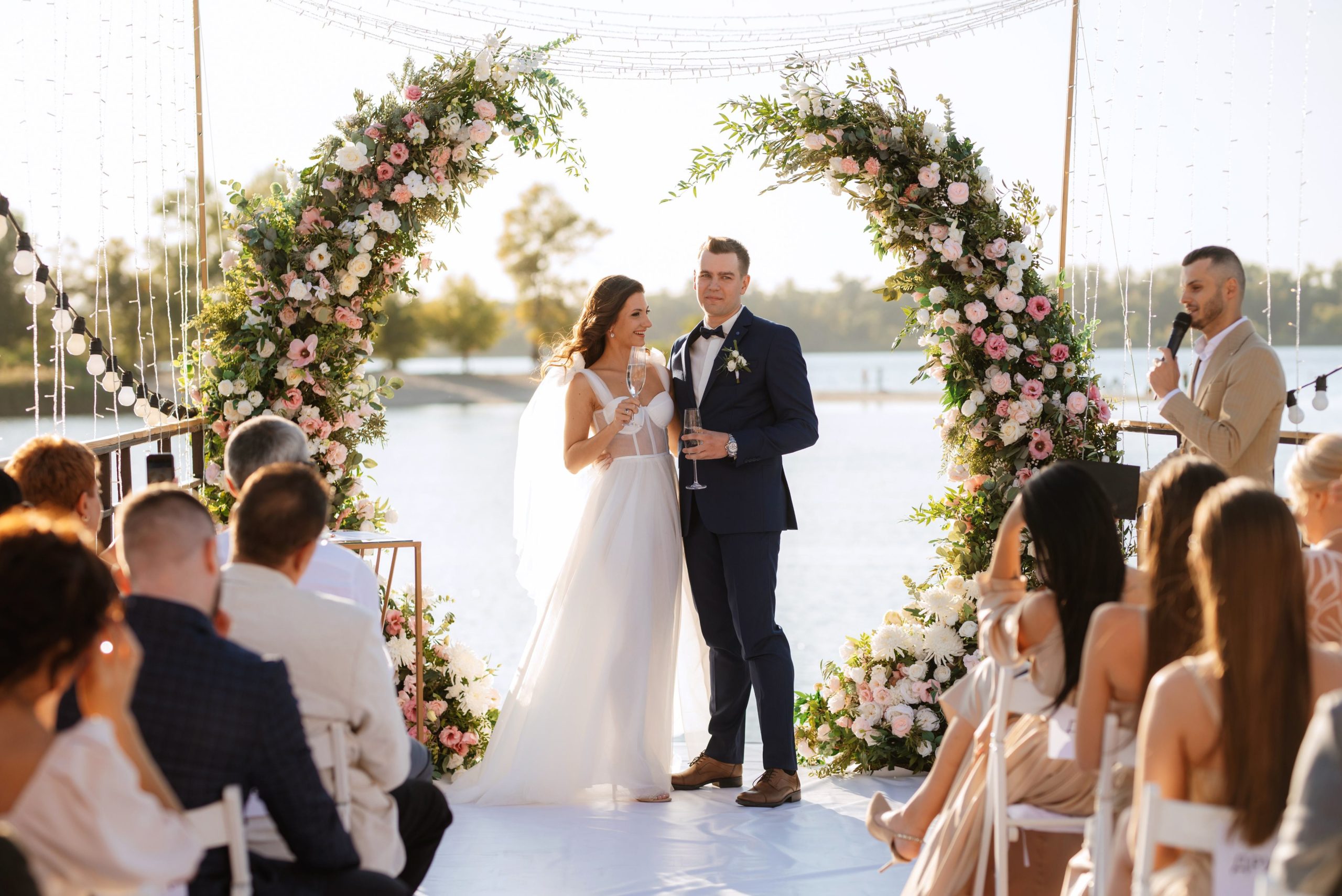Ceremonia con arco de flores frente al agua